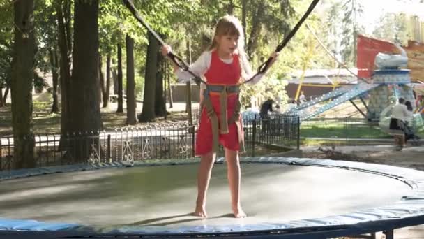 Kind Meisje Springen Vastgemaakt Een Trampoline Zomer Park — Stockvideo