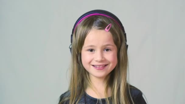 Bastante Chica Cild Sonriente Escuchando Música Grandes Auriculares Rosados — Vídeos de Stock