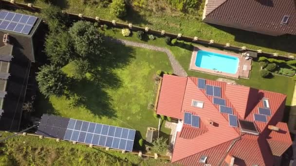 屋根に太陽光パネルと給湯ラジエーターと青いスイミングプールと緑の庭を持つ新しい自律的な家の空中ビュー — ストック動画