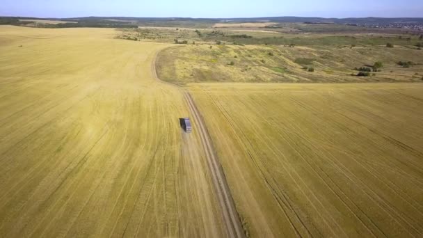 从空中看一辆卡车在犁地之间的土路上行驶 产生了大量灰尘 — 图库视频影像
