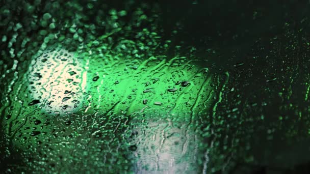 Sluiten Van Regenwater Druppels Autoraam Glas Met Wazig Verkeer Lichten — Stockvideo