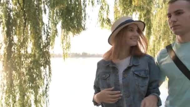 Feliz Pareja Adolescentes Caminando Parque Otoño Orilla Del Lago Charlando — Vídeo de stock