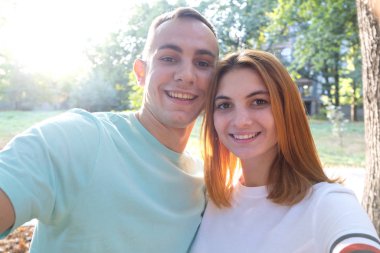 Sıcak ve güneşli bir havada selfie çeken mutlu genç çift..