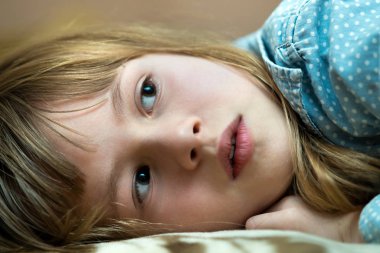 Portrait of a pretty child girl laying down at home.