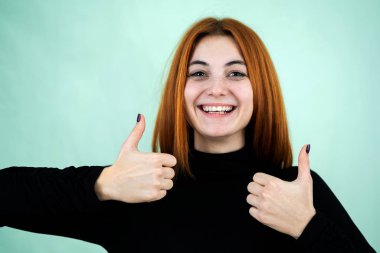 Komik, güzel, kızıl saçlı kız parmaklarıyla işaret veriyor.