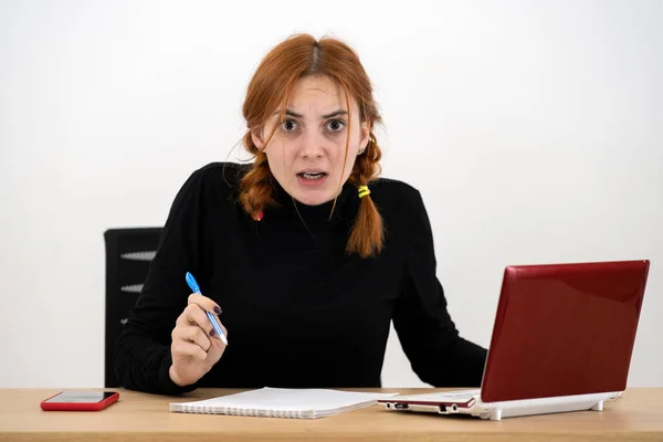 Shocked grave joven oficinista mujer sentado detrás de trabajo — Foto de Stock