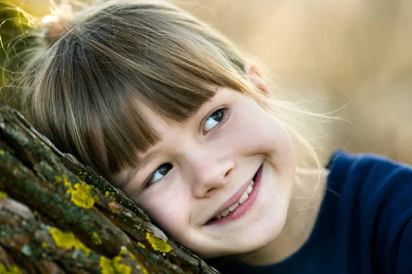 Portrait d'une jolie enfant fille penchée vers un tronc d'arbre dans l'autum — Photo