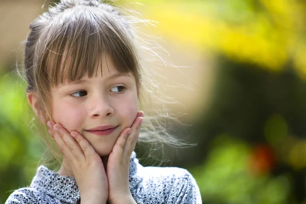 Portrait de mignonne jolie fille réfléchie enfant en plein air sur flou — Photo