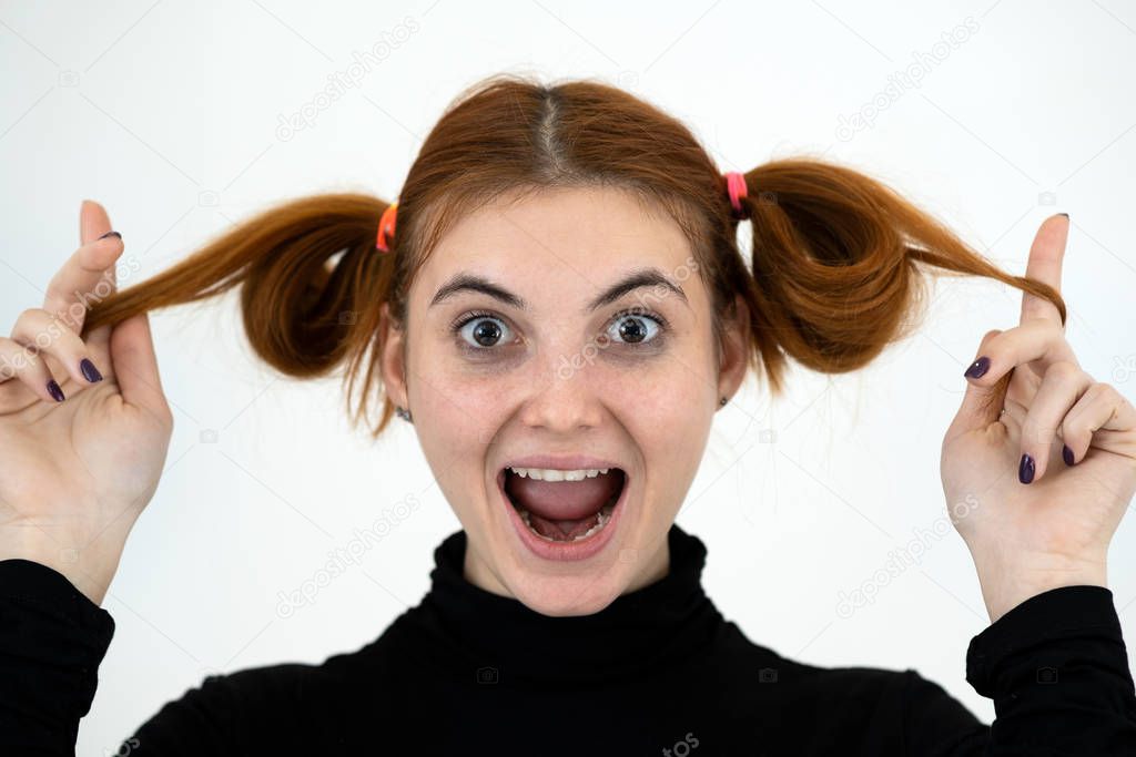 Closeup portrait of a funny redhead teenage girl with childish h