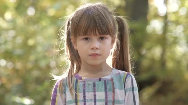 Portrait d'enfant heureux fille souriant à la caméra sur fond flou lumineux .