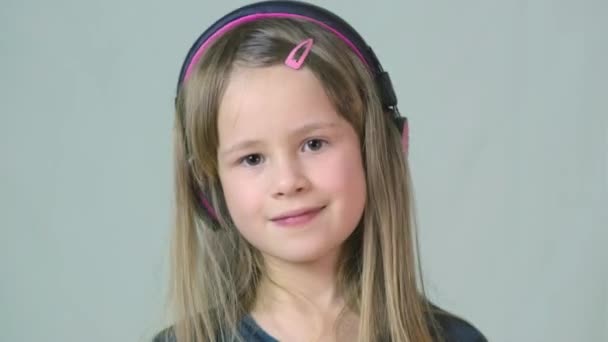 Bastante Chica Cild Sonriente Escuchando Música Grandes Auriculares Rosados — Vídeos de Stock