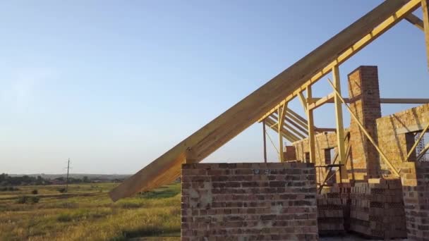 Aerial view of unfinished brick house with wooden roof structure under construction. — Stock Footage Aerial View Unfinished Brick House Wooden Roof Structure Construction Royalty Free Stock Video