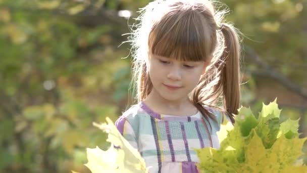 幸せな子供の女の子の肖像画笑顔でカメラで明るいぼやけた背景 — ストック動画