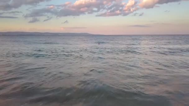 夕日の空の下で青い水の波と海の表面の空中写真 — ストック動画