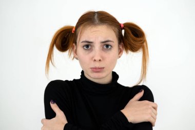 Üzgün, kızıl saçlı, çocuksu bir kızın yakın plan portresi.