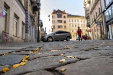 Bulanık arabalı taş kaldırım. Şehir caddesine park edilmiş.