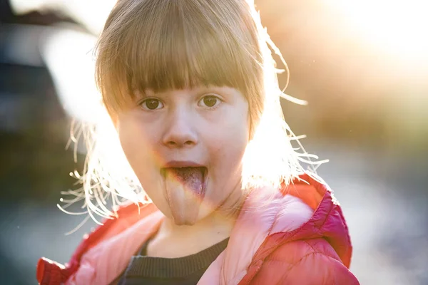 Portrait d'une jolie fille enfant montrant sa langue à l'extérieur . — Photo