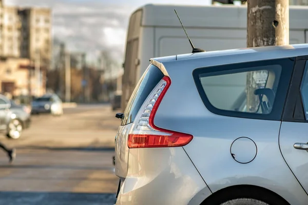 Güneşli bir günde şehir sokağının kenarına park edilmiş modern arabalar..