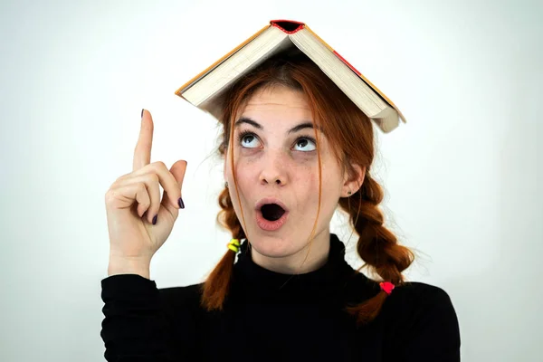 Portrait of funny young smiling student girl with an open book o Stock Picture