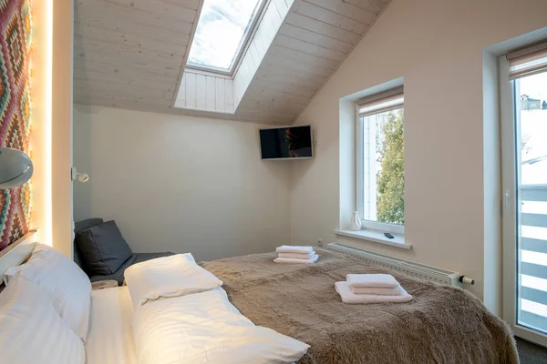 Interior of a spacious hotel bedroom on attic floor with fresh l — ストック写真