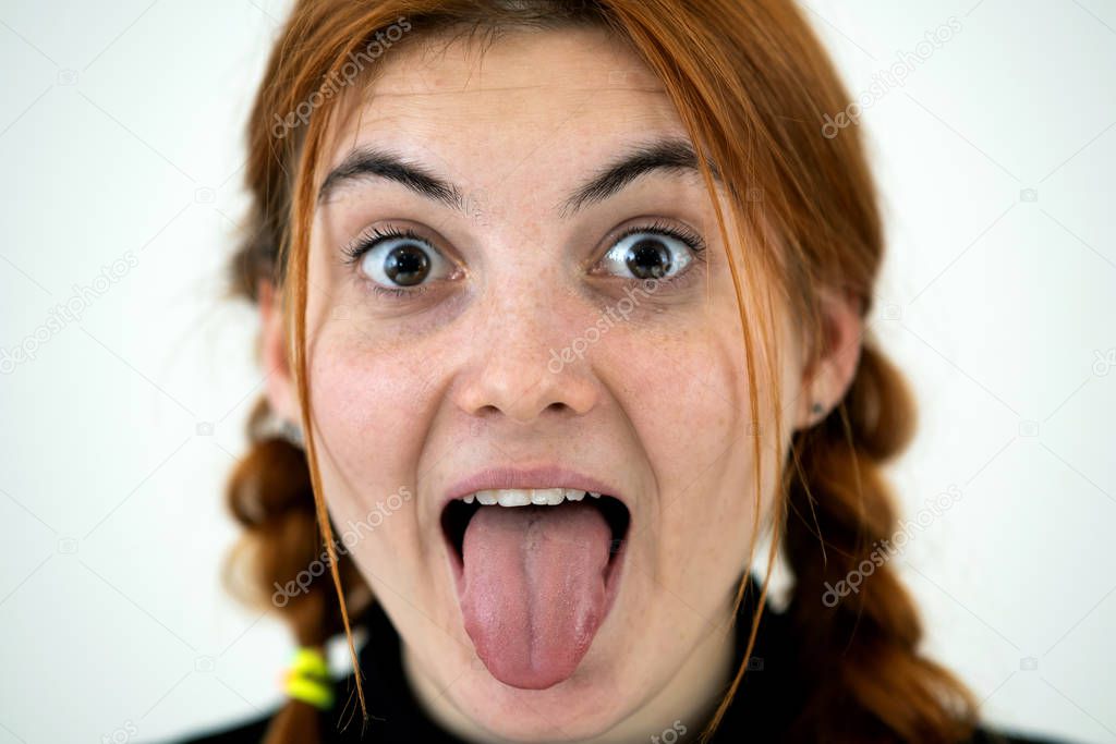 Closeup portrait of a funny redhead teenage girl with childish h