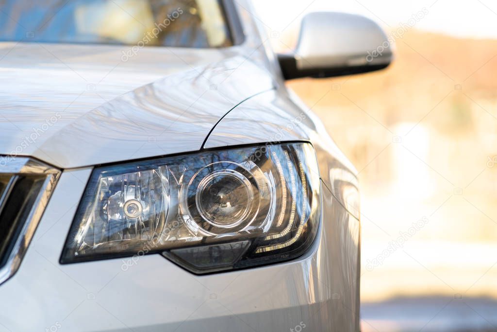 Close up view of modern car headlight with shiny optics.