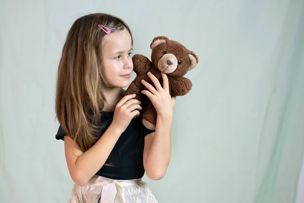 Menina bonita brincando com seu brinquedo de urso de pelúcia . — Fotografia de Stock