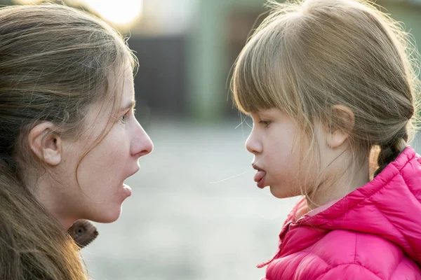 Close up portrait of young mom and her daughter girl making face — 스톡 사진