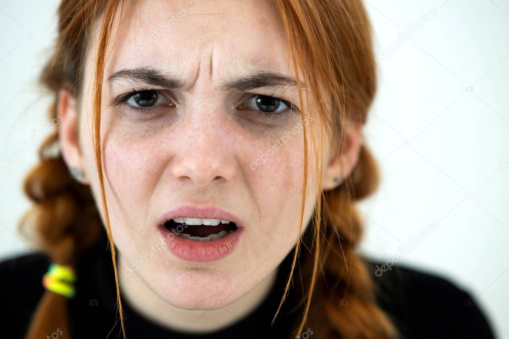 Close up portrait of angry redhead teenage girl.