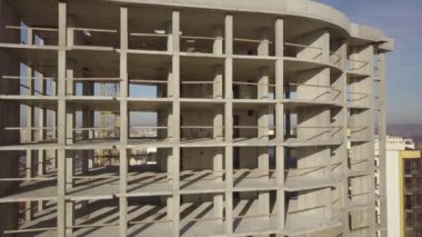 Bir şehirde inşaat halindeki yüksek apartmanın beton çerçevesinin havadan görünüşü.