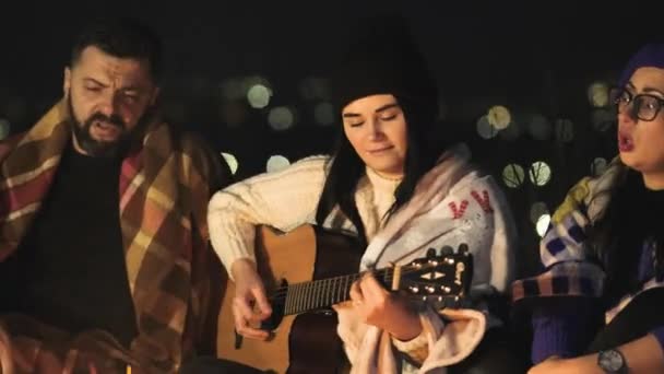 Grupo Pessoas Divertindo Sentadas Perto Fogueira Livre Noite Tocando Guitarra — Vídeo de Stock