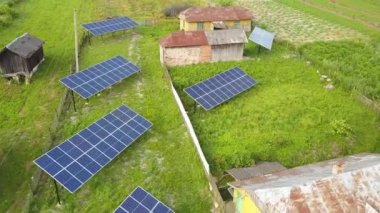 Yeşil kırsal alandaki güneş panellerinin yukarıdan aşağıya görüntüsü.