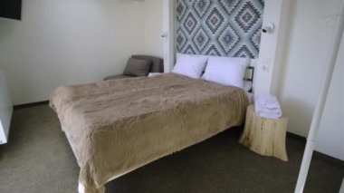 Çatı katında geniş bir otel odasının içinde büyük bir çift kişilik yatağın üzerinde temiz çarşaflar. Modern bir evdeki modern Mansard odası..