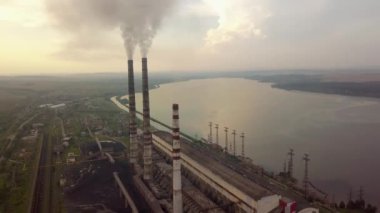 Kömür santralinden gelen gri dumanlı yüksek baca borularının havadan görüntüsü. Fosil yakıtla elektrik üretimi.