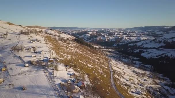 Luftaufnahme Eines Kleinen Dorfes Mit Verstreuten Häusern Auf Schneebedeckten Hügeln — Stockvideo