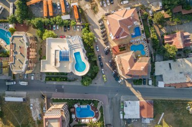 Otellerin çatıları, park etmiş arabaların olduğu sokaklar ve deniz kenarındaki tatil köylerinde mavi suyu olan yüzme havuzları..