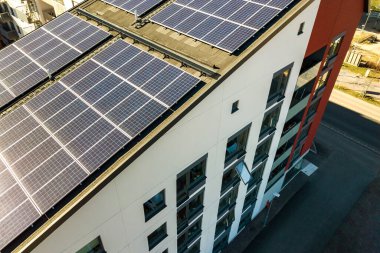 Temiz elektrik üretmek için konut bloğunun çatısındaki güneş fotovoltaik panellerin hava görüntüsü. Özerk konut kavramı.