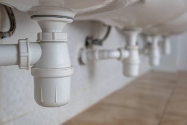 Banyodaki lavabonun altındaki beyaz plastik boruyu kapat..