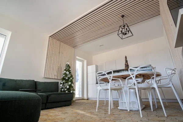 白い壁 装飾的な木製の要素 現代的な家具や大きな柔らかいソファ付きのモダンな広々としたキッチンのインテリア — ストック写真