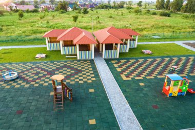 Aerial view of new alcove in kindergarten play yard with red tiled roof for outdoor children activities. clipart