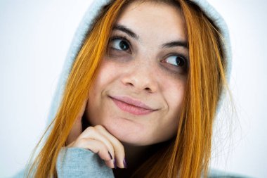 Sıcak kapüşonlu kazak giyen mutlu, genç, kızıl saçlı kadının yakın portresi..