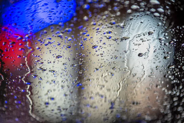 Abstrakter Farbenfroher Hintergrund Der Glasoberfläche Mit Wassertropfen Und Verschwommenem Stadtlicht — Stockfoto