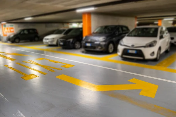 Marcas Amarillas Con Coches Modernos Borrosos Estacionados Dentro Estacionamiento Subterráneo — Foto de Stock