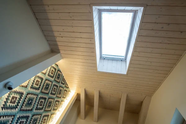 Wooden ceiling in a contemporary mansard room with attic window ob decorative planks surface. — Stock Image Wooden Ceiling Contemporary Mansard Room Attic Window Decorative Planks Surface Stock Image