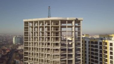 Bir şehirde inşaat halindeki yüksek apartmanın beton çerçevesinin havadan görünüşü.