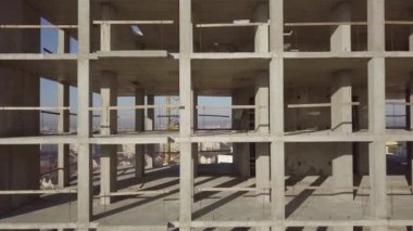 Bir şehirde inşaat halindeki yüksek apartmanın beton çerçevesinin havadan görünüşü.