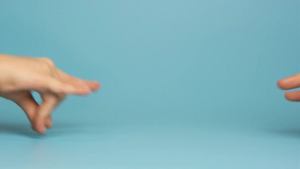 Крупним Планом Дві Дитячі Руки Грають Разом Ізольовано Синьому Фоні — стокове відео