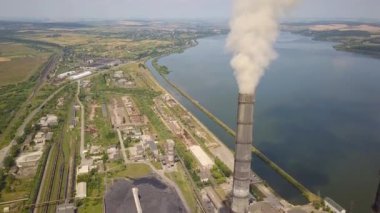 Kömür santralinden gelen gri dumanlı yüksek baca borularının havadan görüntüsü. Fosil yakıtla elektrik üretimi.