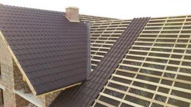 İnşaat halindeki metal kiremitlerle kaplı ahşap çatı yapısı olan bitmemiş evin havadan görüntüsü..