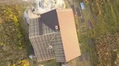 İnşaat halindeki metal kiremitlerle kaplı ahşap çatı yapısı olan bitmemiş evin havadan görüntüsü..